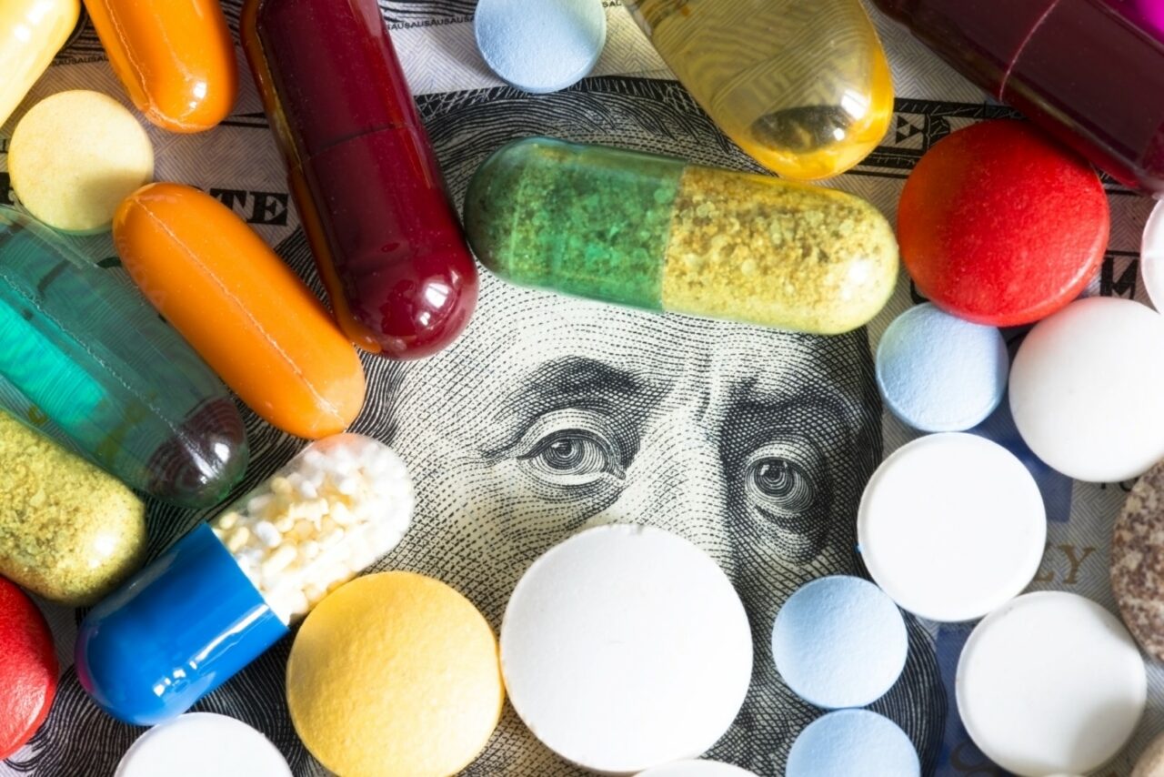 Health care or medical cost concept with many colourful pills on US dollar cash banknote