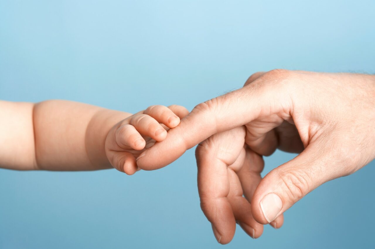 Closeup Of Baby Holding Man's Finger