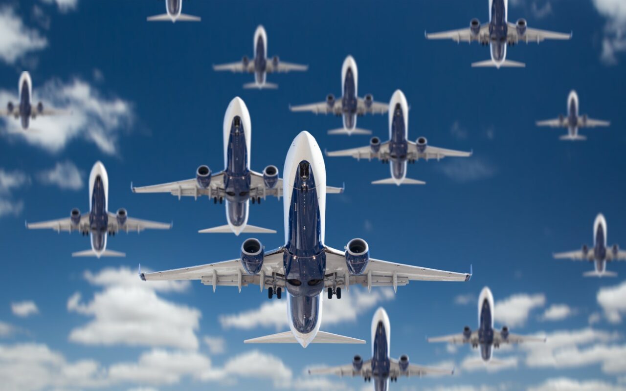 Bottom View of Several Passenger Airplanes Flying In The Blue Sky.