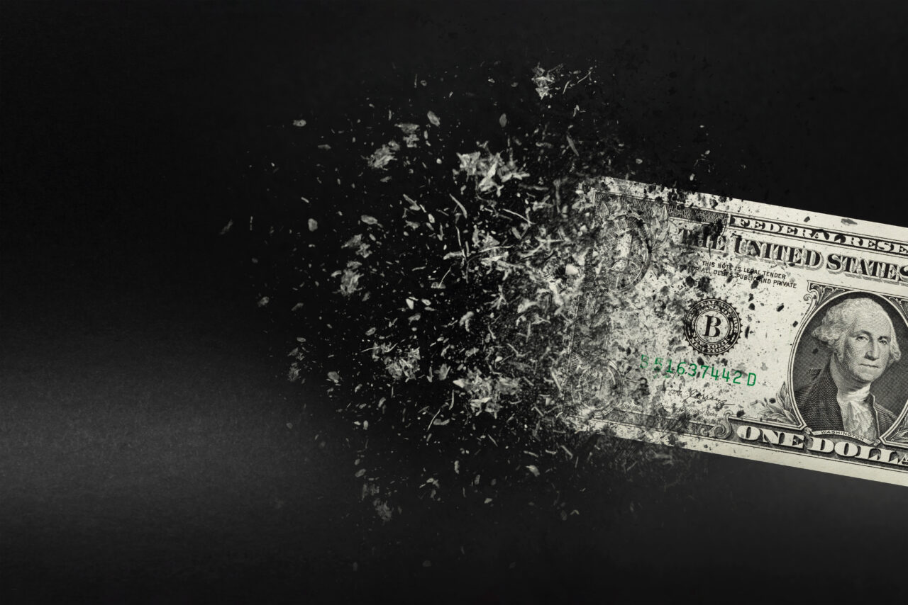 Inflation, dollar hyperinflation with black background. One dollar bill is sprayed in the hand of a man on a black background. The concept of decreasing purchasing power, inflation.