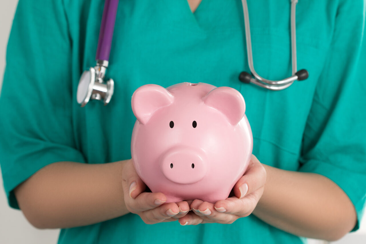 Female Doctor Holding Piggy Bank
