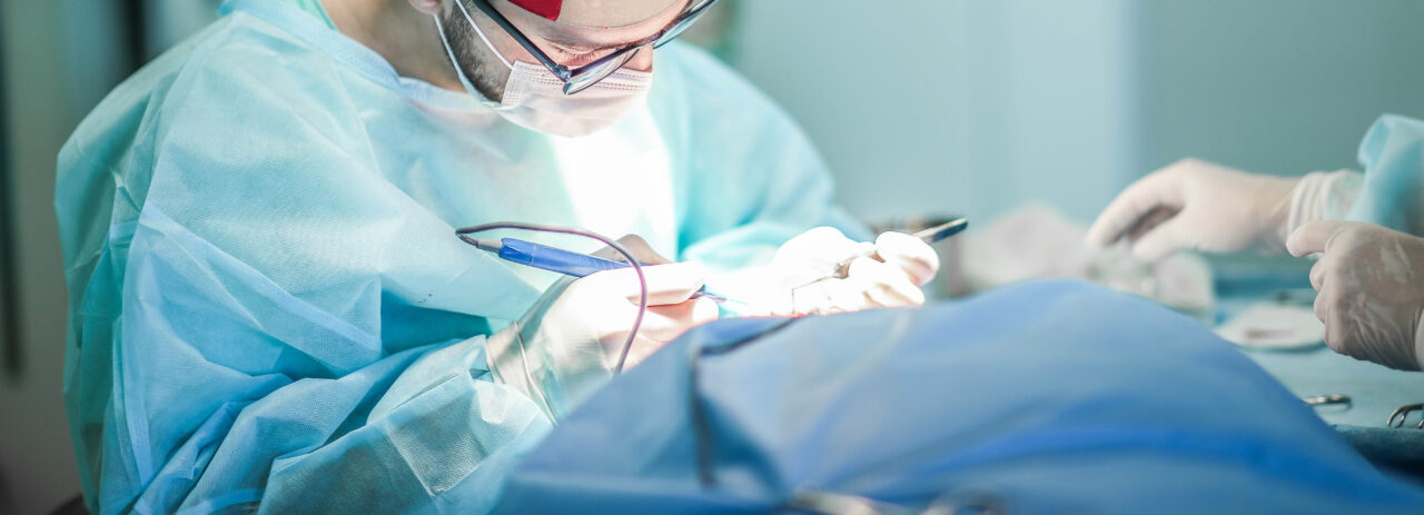 Young male plastic surgeon operates in the operating room of a m