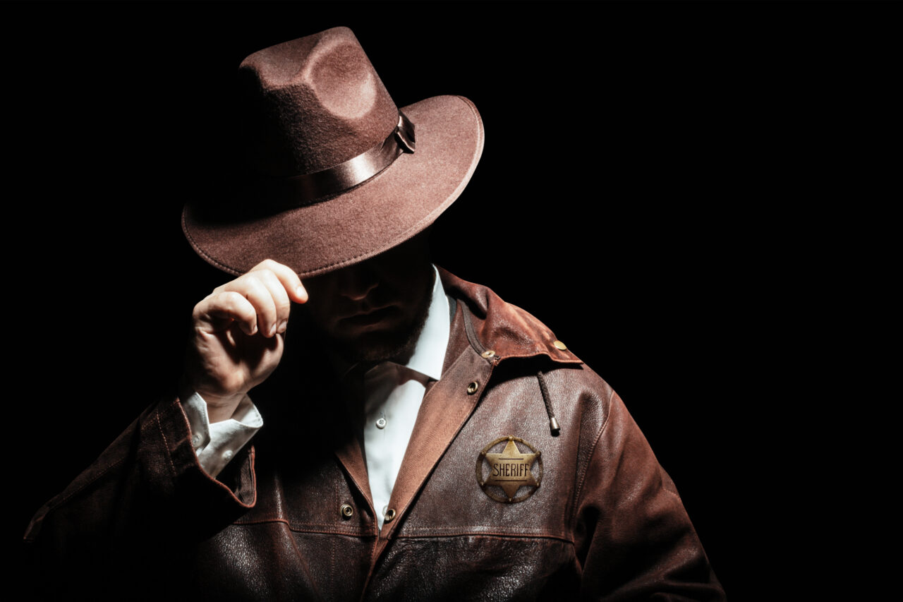 Sheriff in hat with badge.