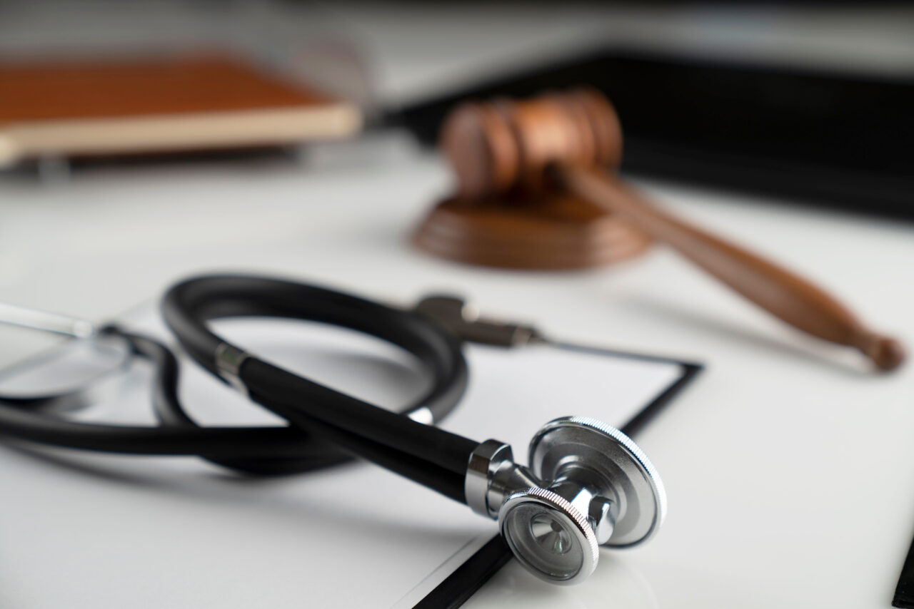 Medical law concept. Gavel, notebook and stethoscope on the whit