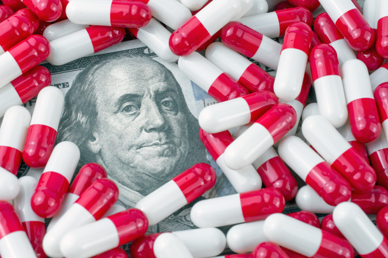 prescription drug prices concept. money with pills background