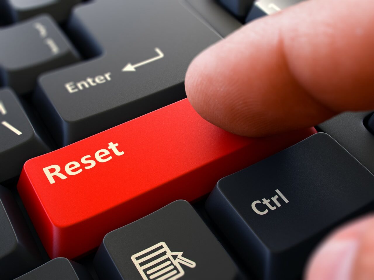 Finger Presses Red Keyboard Button Reset.