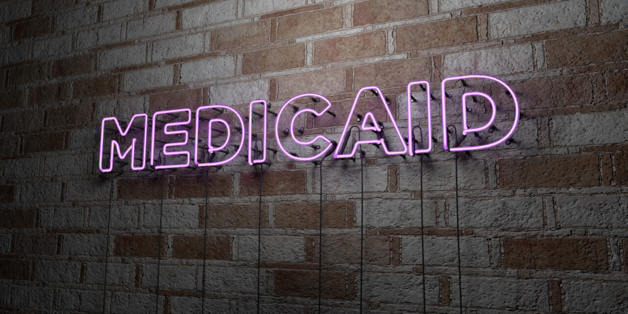 MEDICAID - Glowing Neon Sign on stonework wall