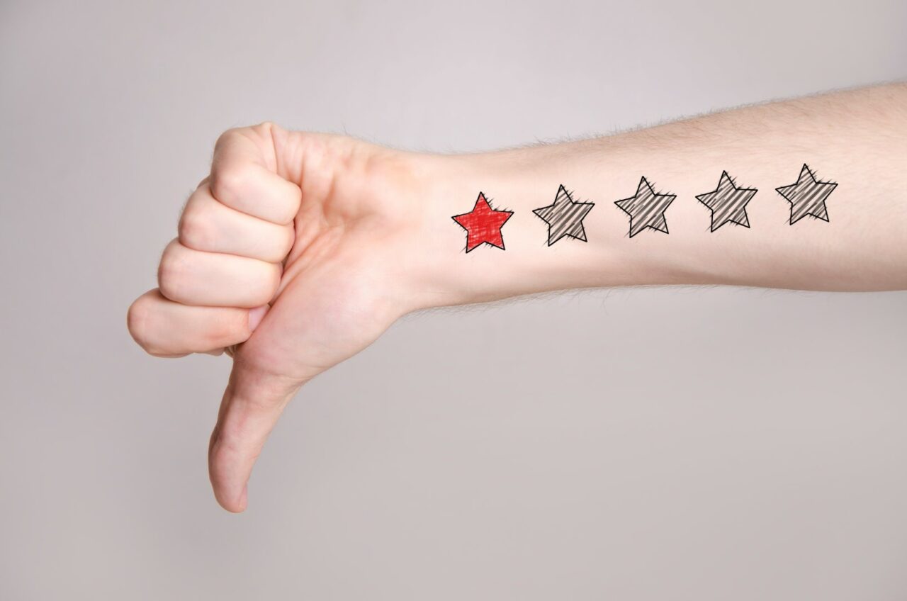 Man hand showing thumbs down and one star rating on the arm skin
