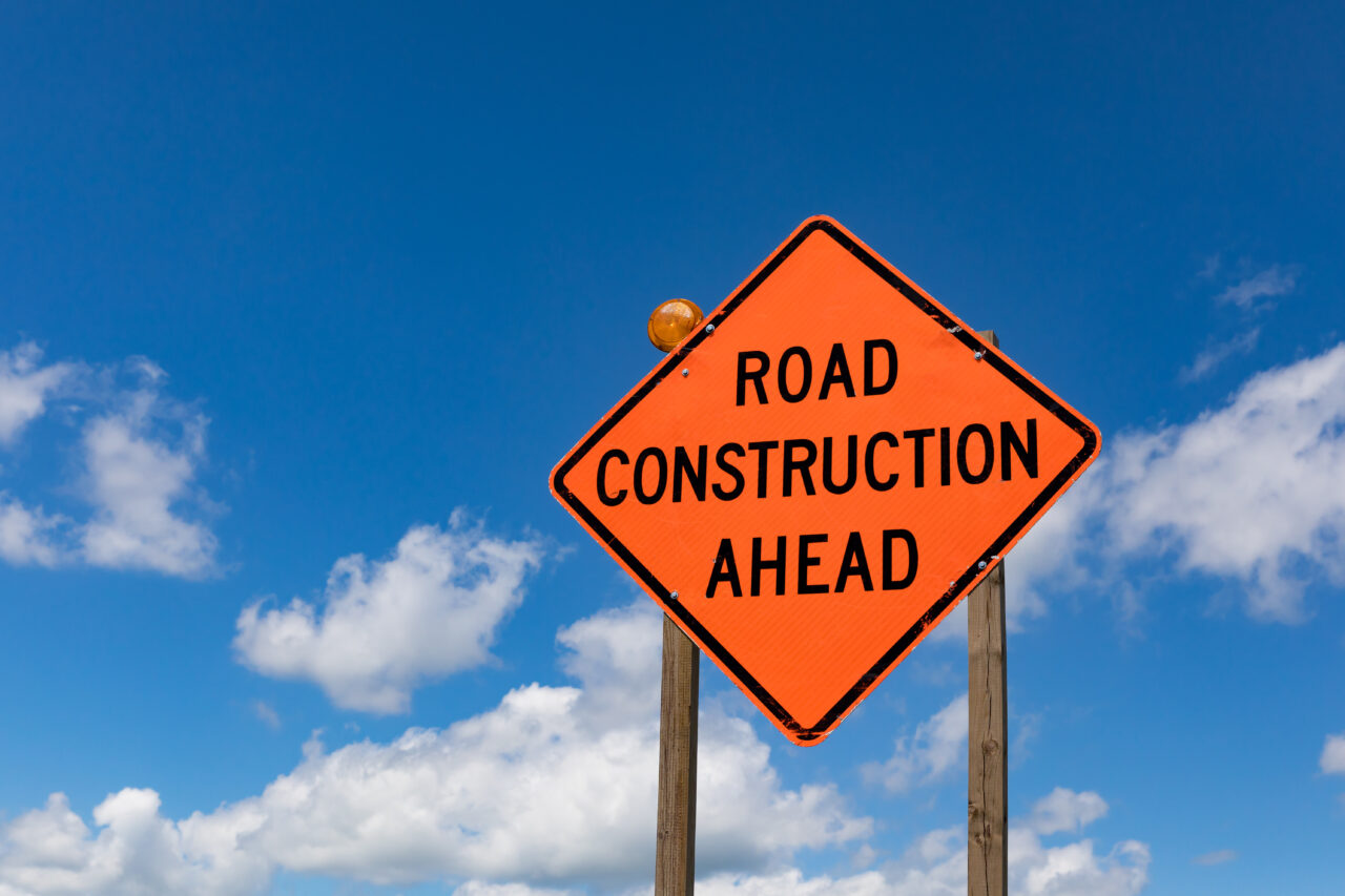 closeup of road construction ahead sign and warning light with b