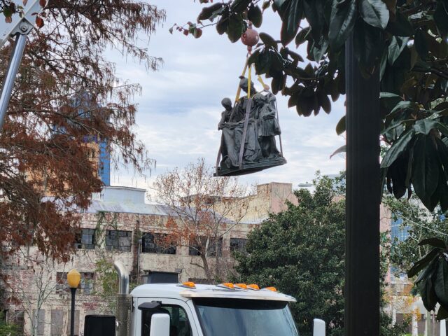 A Confederate monument statue is hoisted away by a crane Wednesday at Springfield Park in Jacksonville. Photo By Drew Dixon