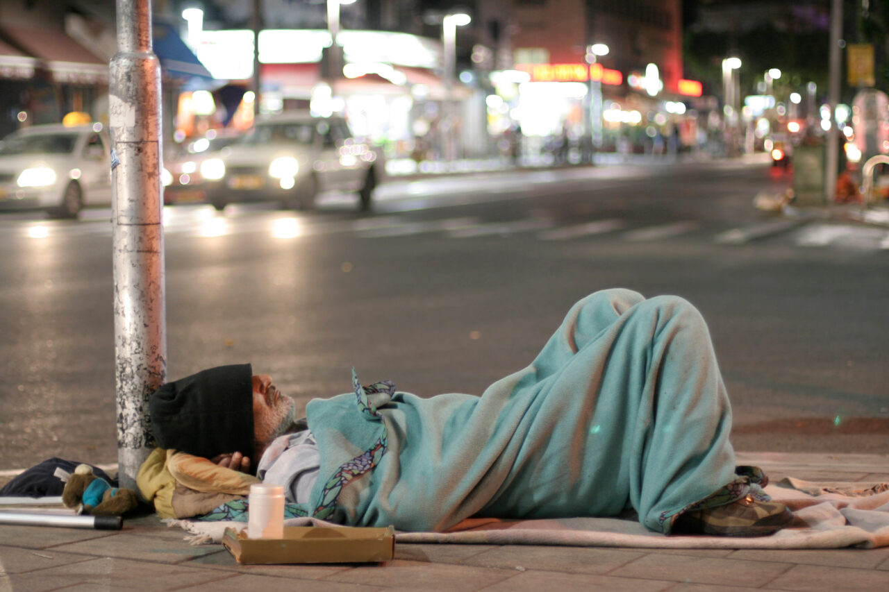 male homeless sleeping in a street