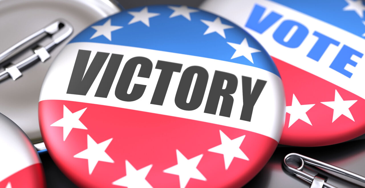 Victory and elections in the USA, pictured as pin-back buttons with American flag colors, words Victory and vote, to symbolize that t can be a part of election or can influence voting, 3d illustration