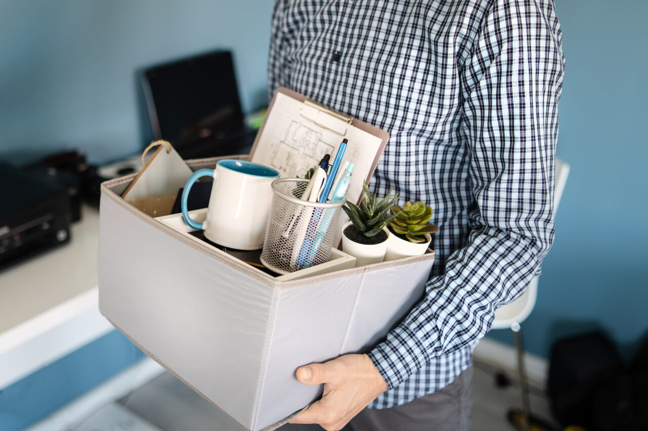 Midsection close up of unknown caucasian man holding a box with personal items stuff leaving the office after being fired from work due recession economic crisis downturn losing job company shutdown