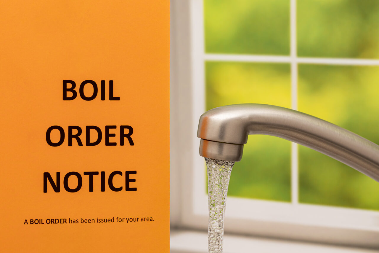 Boil order notice and kitchen faucet. Clean, contaminated, dirty or broken drinking water supply concept.