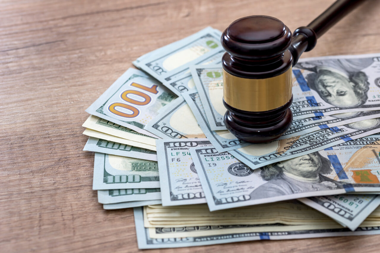 wooden gavel with usa dollar on desk. close up.