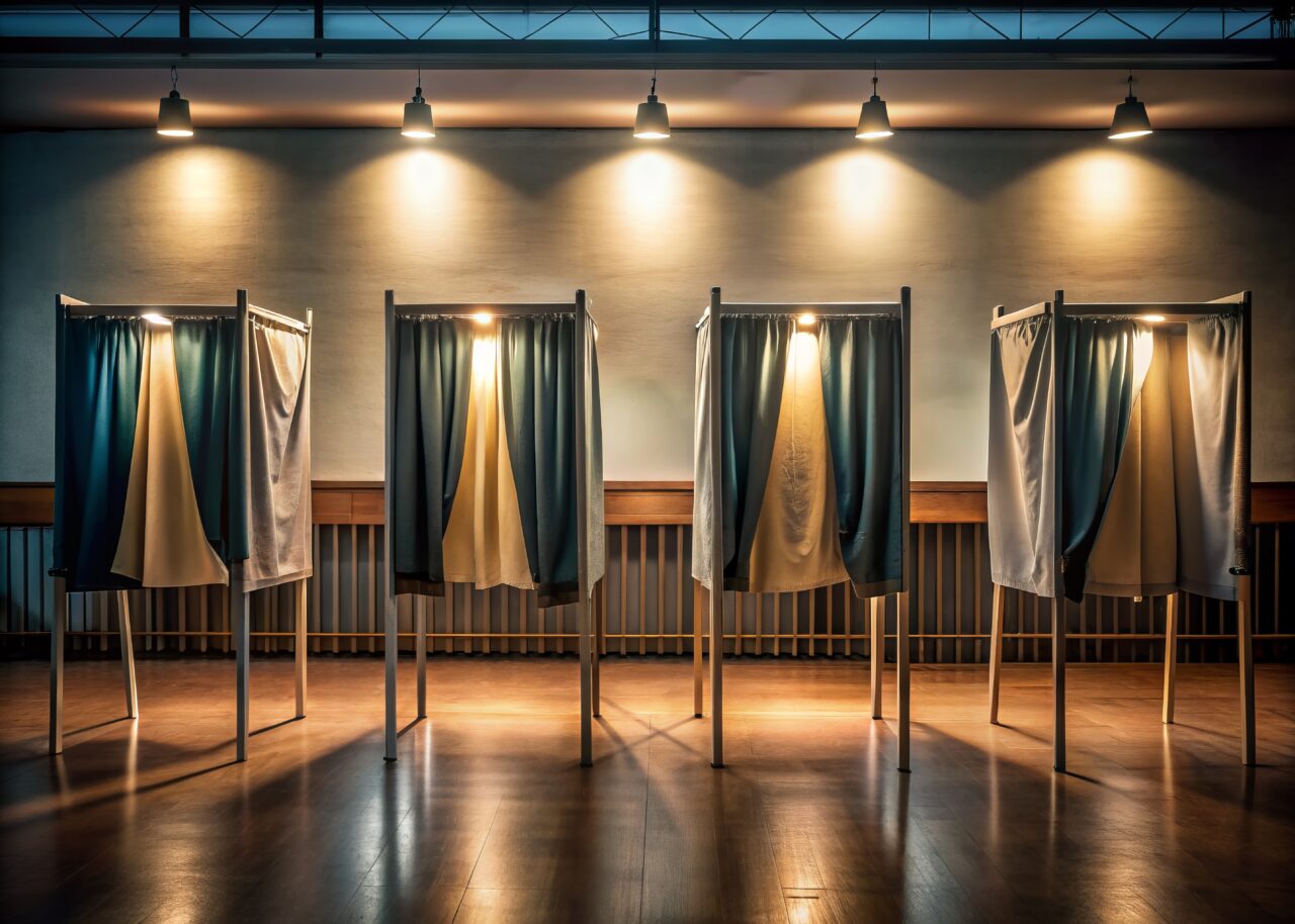 Dimly lit polling station with private voting booths lined up in a row, curtains drawn, ensuring secrecy and solitude for democratic decision-making process.