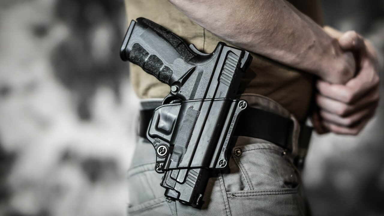 Man openly carrying a pistol on his belt. Open carry and second amendment concept.